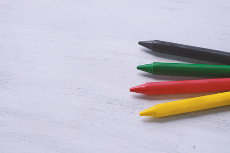 Close up view of colorful wax crayons on white wooden background.の写真素材