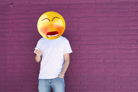 Sad Emoji head man using a smartphone. Emoji conceptの写真素材