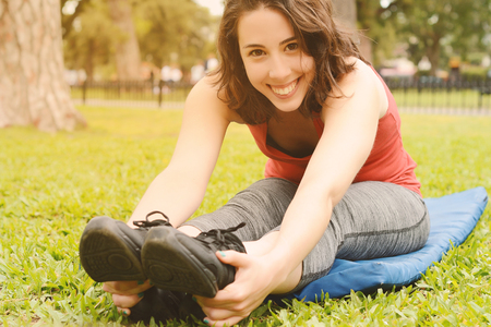 Portrait of sport woman streching legs. Outdoors