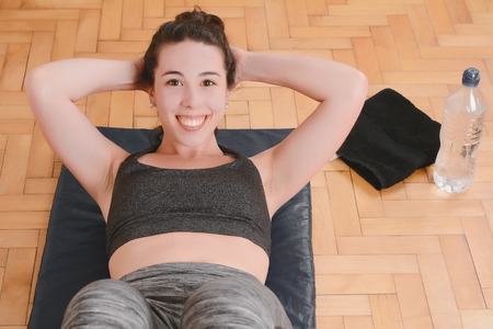 Fitness woman doing crunches at gym. Sport concept. Indoors