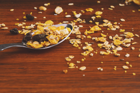 Spoon with granola cereals on wooden background. Healthy concept