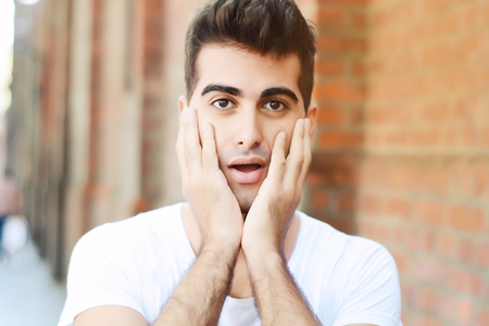 Portrait of young latin man in worried face expression. Outdoorsの写真素材