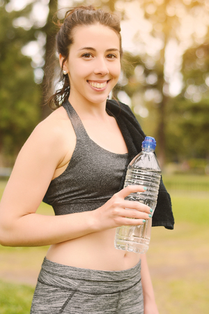 Portrait of sportswoman drinking water after workout. Outdoorsの写真素材