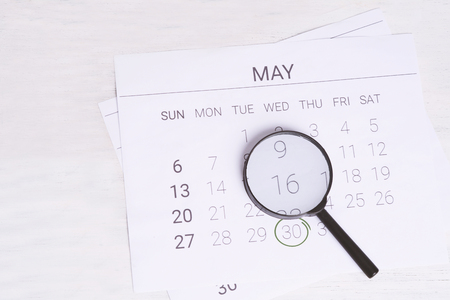Concept image of business and meetings. Calendar to remind you an important appointment and Magnifying glass in May.の写真素材