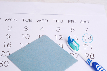 Calendar with toothbrush to remind dentist appointment day. Dental hygiene and healthy concept.の写真素材