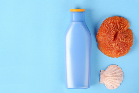 Top view of shells, starfish and sunblock with copyspace. Summer concept. Light blue backgroundの写真素材