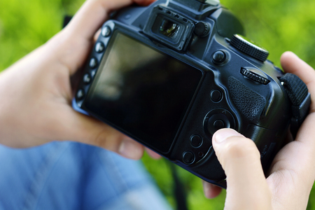 Young latin woman looking at photo camera in the park. Professional woman working. Outdoorsの写真素材