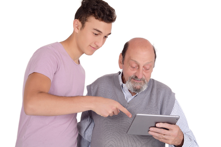 Teenage boy showing grandmother how to use digital tablet. Technology concept. Isolated white backgroundの写真素材