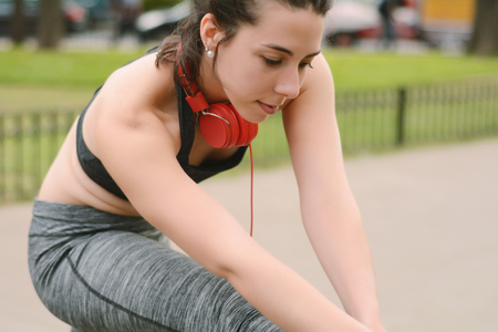 Portrait of sport woman streching legs. Outdoorsの写真素材
