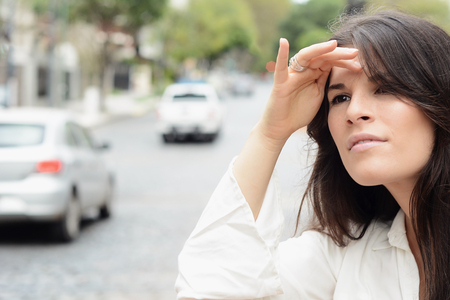 Young woman looking for a taxi on city. Urban life and transportation concept.の写真素材