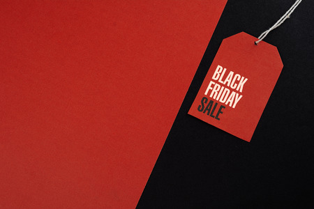 Sale tag with discount witen in it on black and red background. Black friday concept