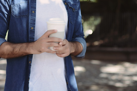 Young handsome man with disposable coffee. Take away concept. Outdoorsの写真素材