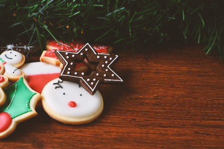 Close up view of colorful Christmas cookies with festive decoration on wooden table. xmas holiday...