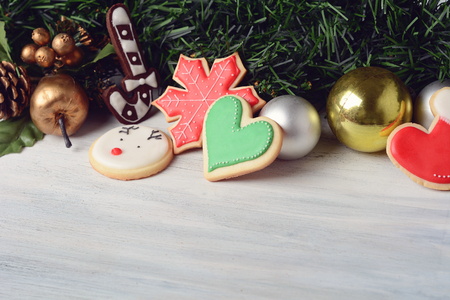 Close up view of Christmas cookies hanging under festive branches fir on wooden table.  xmas holiday concept.の写真素材