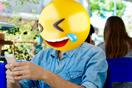 Emoji head man using a smartphone. Emoji conceptの写真素材