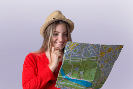 Portrait of young tourist woman looking at map on studio.