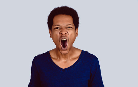 Portrait of Afro American man screaming at camera on studio.の写真素材