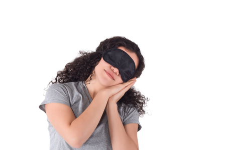 Portrait of Young beautiful woman sleeping with eye mask on white background.  Sleepy beauty woman resting on hand.の写真素材