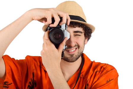 Portrait of a traveler man taking photos with camera on studio. Travel concept.