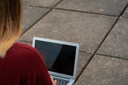 Portrait of young female student using laptop computer outdoors. Education conceptの写真素材