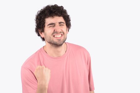 Portrait of young man celebration victory on studio.