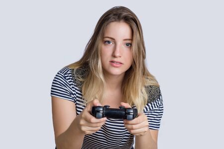 Portrait of young beautiful woman playing video games in studio.