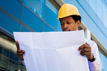 Portrait of Businessman engineer developer holding blueprint working outdoors.
