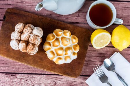 Close-up to delicious mini chocolate cake and lemon pie with cup of tea.の写真素材