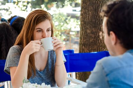 Young attractive couple enjoying a coffee at the coffee shop. Outdoors.