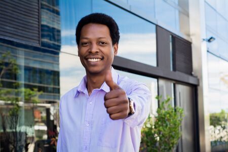 Young urban businessman giving thumb up. Successful businessman.の写真素材