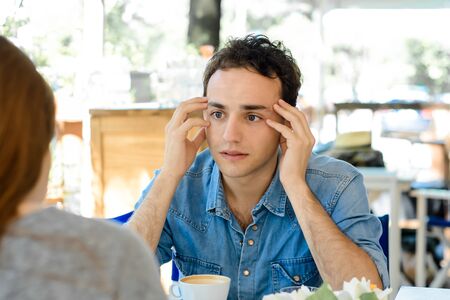 Young handsome man bored at a date in coffee shop.