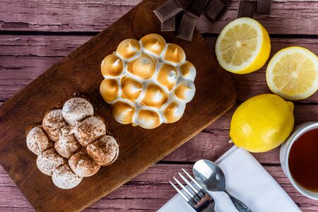 Close-up to delicious mini chocolate cake and lemon pie with cup of tea.の写真素材