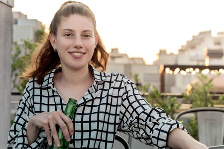 Young woman drinking at rooftop outdoor in urban city background, happy lifestyle.の写真素材