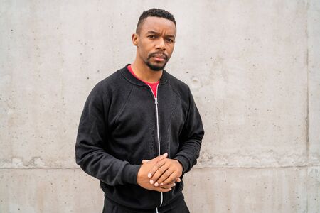 Portrait of an athletic man wearing sport clothes against grey background. Sport and healthy lifestyle.の写真素材