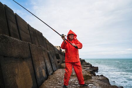 Portrait of an old man fishing in the sea. Fishing concept.