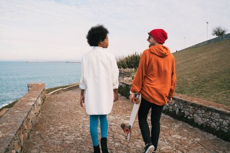Portrait of two young friends spending some nice time together, walking on coast line and having fun.の写真素材