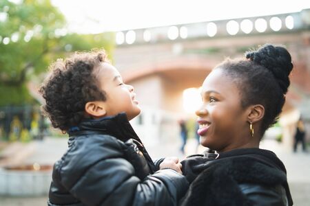 Portrait of an African american mother with his son playing together outdoors in the park and having fun. Monoparental family.の写真素材
