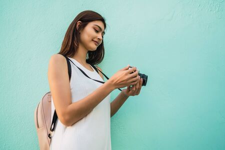 Portrait of young photographer woman using a professional digital camera. Photography concept