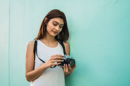 Portrait of young photographer woman using a professional digital camera. Photography concept