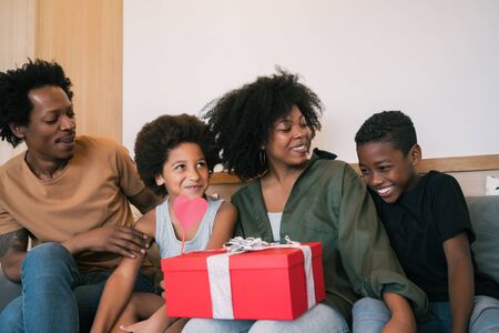 Portrait of father and children congratulate mother on mother's day and give her gifts at home. Mother's day celebration concept.の写真素材