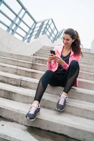 Portrait of an athletic woman using her mobile phone on a break from training. Sport and health...