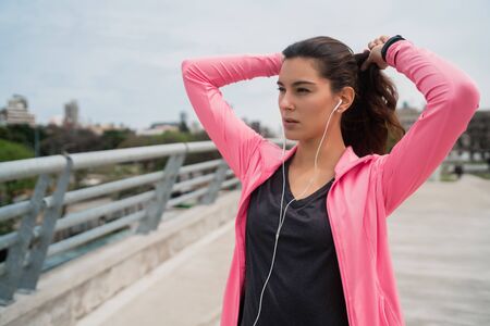 Portrait of an athletic woman listening to music on a break from training. Sport and health lifestyle.の写真素材