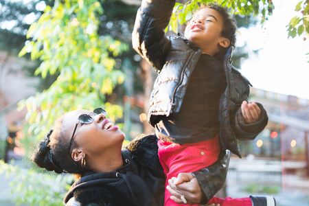 Portrait of an African american mother with his son having some fun outdoors in the park. Monoparental family.の写真素材