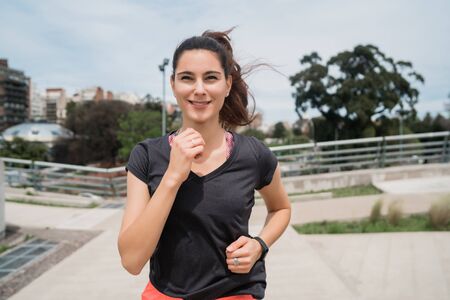 Portrait of a fitness woman running outdoors in the street. Sport and healthy lifestyle.の写真素材