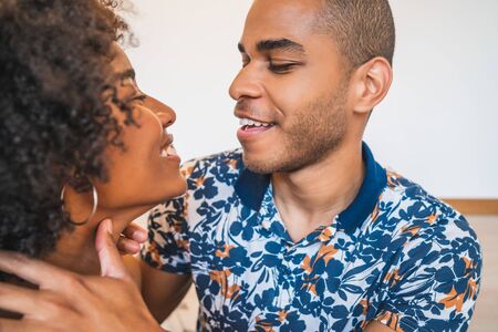 Portrait of happy young couple relaxing and spending weekend together on couch at home. Lifestyle and relationship concept.の写真素材