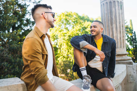 Portrait of happy gay couple spending time together and having a date at the park. Lgbt and love concept.の写真素材