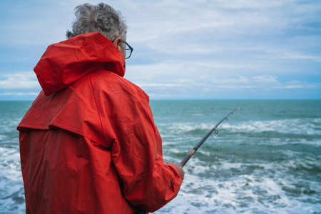 Portrait of an old man fishing in the sea. Fishing concept.の写真素材