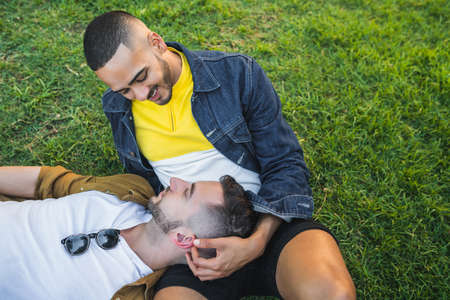 Portrait of happy gay couple spending time together and having a date at the park. Lgbt and love...
