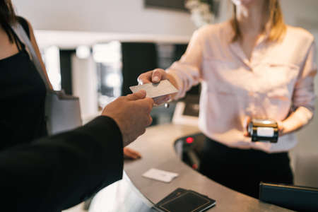 Close up of guest makes card payment at check-in at reception front desk. Travel concept.の写真素材
