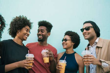 Portrait of afro friends having fun together and enjoying good time while drinking fresh fruit juice.の写真素材